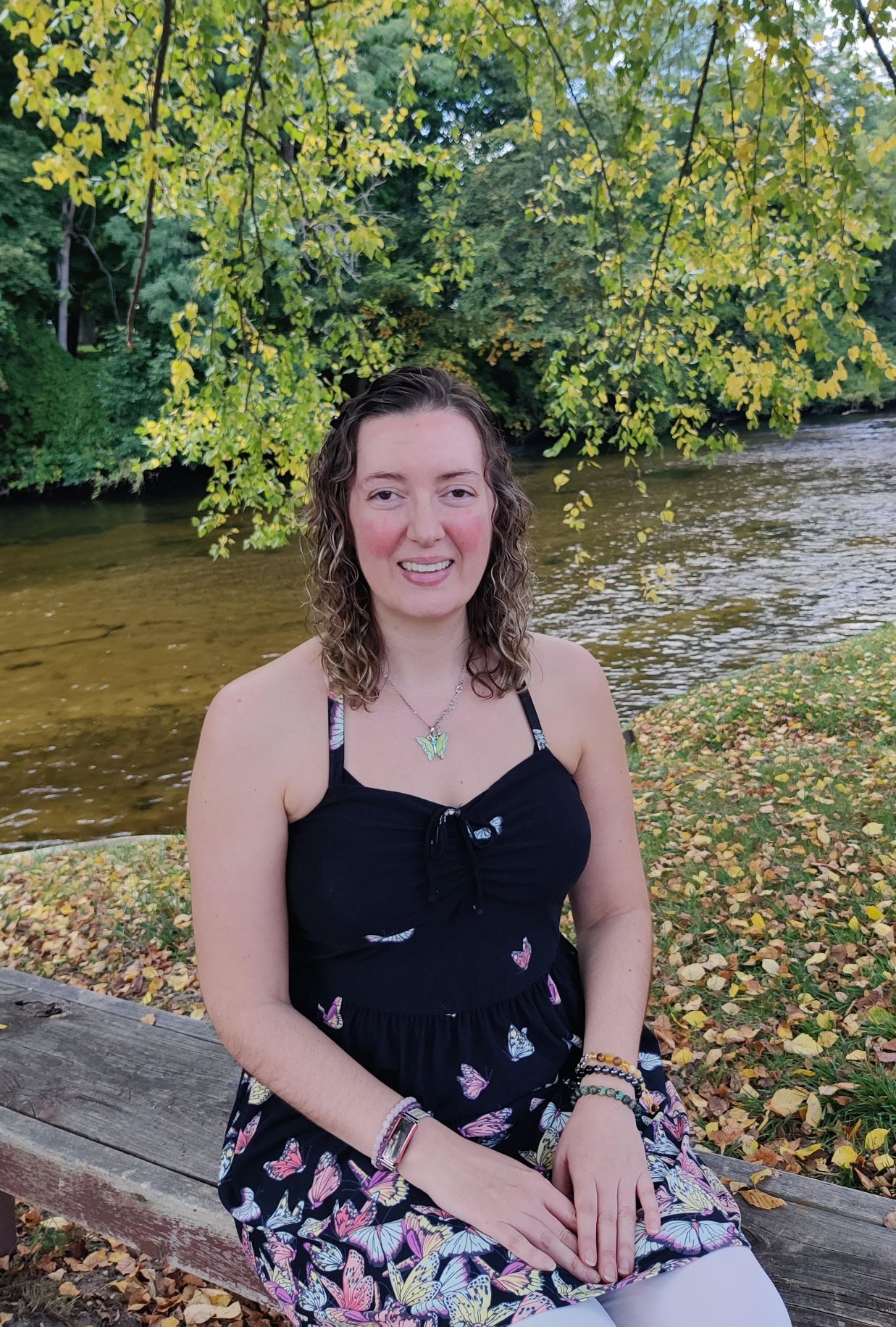 vanessa on bench at a river